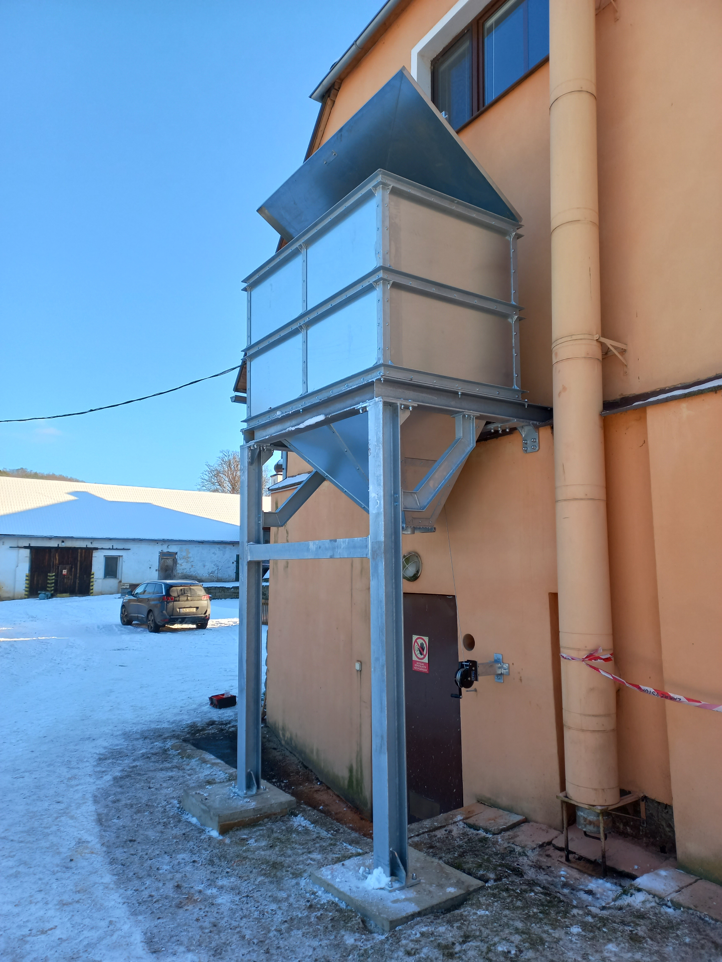 Ocelová násypka — detail bočního pohledu na zinkovanou konstrukci s horním víkem
