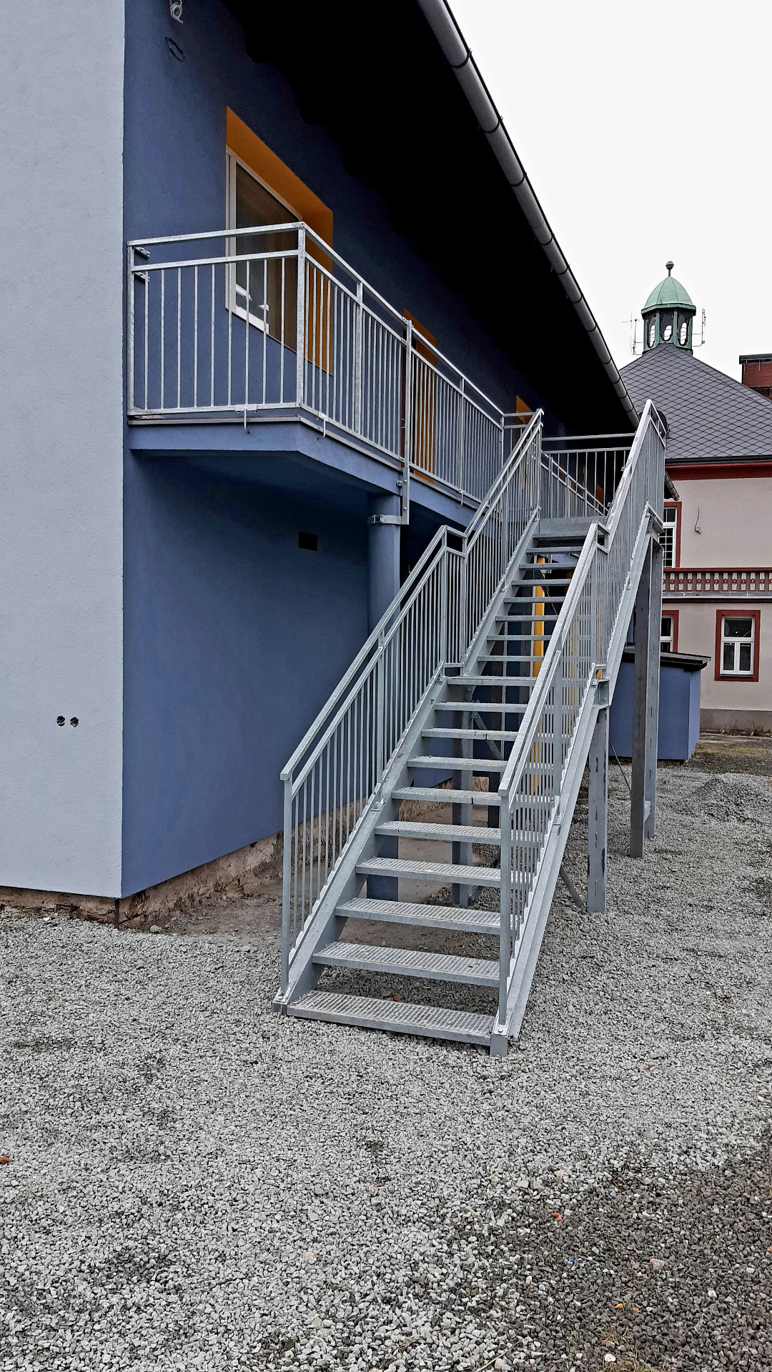 Schodiště zinkované II — detail pozinkovaného schodišťového ramene s tahokovovými stupni a tyčovým zábradlím
